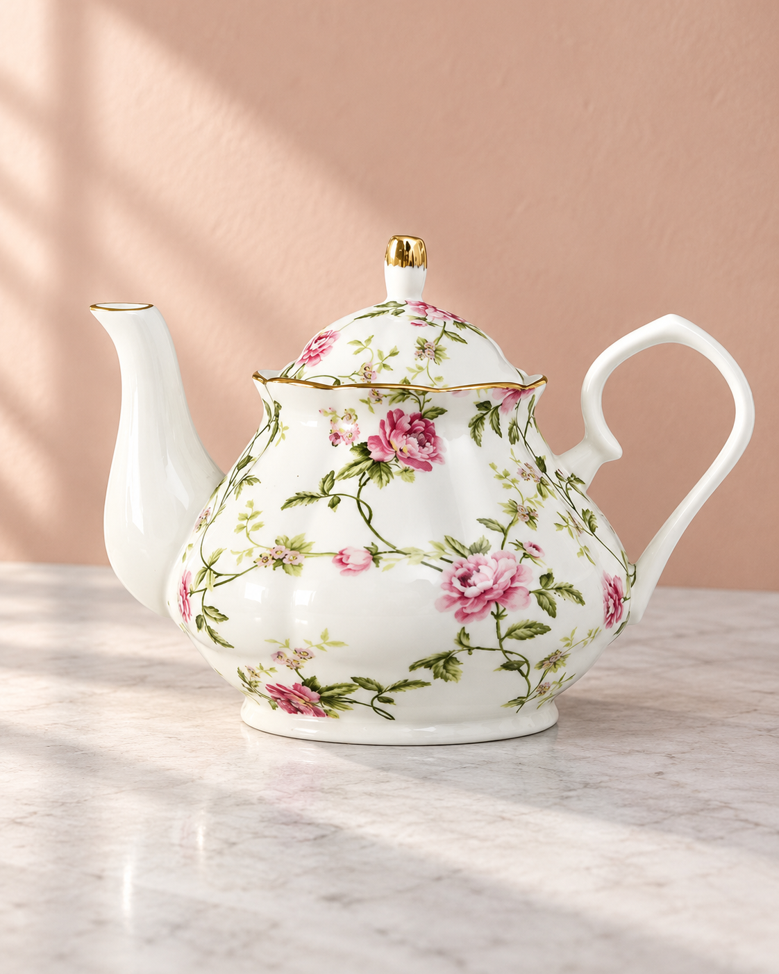White floral teapot with a matching lid, pink flowers and gold trim.