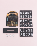 Reading counter kit laid flat: an illustrated bookshelf board, a slotted base, three hooks and three sheets of number cards